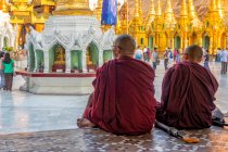 Буддійські монахи дивляться на пагоду Шведгон в історичному храмовому комплексі, Янгон, М 