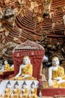 Alter Tempel mit Buddhas-Statuen und religiösen Schnitzereien auf Kalksteinfelsen in der heiligen Kaw Goon Höhle in der Nähe von Hpa-An in Myanmar — Stockfoto