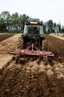 Rear view of tractor plowing a field on a farm. — Stock Photo