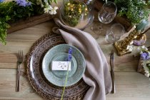 High angle close up of rustic place setting for a woodland naming ceremony. — Stock Photo