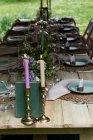 Table à manger avec bougies et décors rustiques pour une cérémonie de baptême des bois. — Photo de stock
