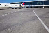 Здания аэропорта и пассажирский самолет на земле — стоковое фото