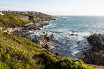 View from above of a jagged rocky coastline, cliffs and path to the beach and the sea. — Stock Photo