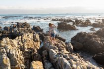 Jeune garçon escaladant et explorant les rochers et les piscines, De Kelders, Western Cape, Afrique du Sud. — Photo de stock