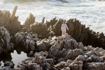 Zwei Kinder erkunden die zerklüfteten Felsen und Felspfützen an der Atlantikküste, De Kelders, Westkap, Südafrika. — Stockfoto