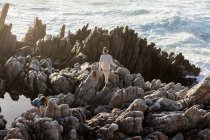 Deux enfants explorent les rochers déchiquetés et les piscines rocheuses sur la côte de l'océan Atlantique, De Kelders, Western Cape, Afrique du Sud. — Photo de stock
