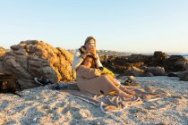 Жінка та її син сидять на піску серед скель на березі біля міста Де Крейдерс на заході сонця.. — стокове фото