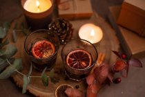 Natal, copos de vinho de vinho quente, velas acesas e decorações de mesa — Fotografia de Stock