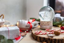 Decorazioni natalizie, una palla di neve e regali e biscotti a forma di stella. — Foto stock