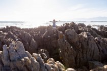 Garçon explorant les rochers déchiquetés et les piscines rocheuses sur la côte de l'océan Atlantique, De Kelders, Western Cape, Afrique du Sud. — Photo de stock