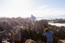 Due bambini che esplorano le rocce frastagliate e le piscine rocciose sulla costa atlantica, De Kelders, Western Cape, Sud Africa. — Foto stock
