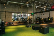 Sala de pesas y equipo de ejercicio en un gimnasio vacío. - foto de stock