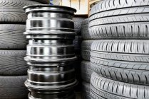 Stack of car tyres and wheel rims in an auto repair shop garage. — Stock Photo
