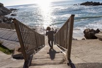 Хлопчик біжить до пляжу вниз набір кроків — стокове фото