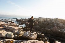Ragazza adolescente camminando attraverso rocce frastagliate, esplorando piscine rocciose in riva al mare — Foto stock