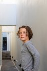 Портрет мальчика в узком переулке, поворачивающегося посмотреть в камеру — стоковое фото
