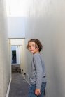 Portrait of young boy in alleyway, turning around to look at the camera. — Stock Photo