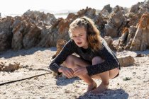 Teenage girl collecting shells on a sandy beach — Stock Photo