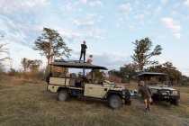 Deux enfants sur le toit d'un véhicule safari lors d'une balade au lever du soleil — Photo de stock
