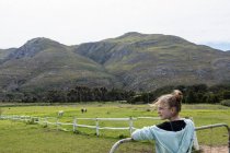 Teenage girl looking at horses, Stanford, Sudafrica — Foto stock