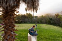 Девочка-подросток играет на гитаре и поет на открытом воздухе — стоковое фото