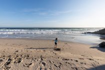 Молодий хлопчик біжить у відкритому просторі на березі Атлантичного океану.. — стокове фото