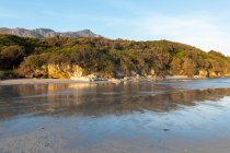 Paysages boisés et montagneux, une petite plage de sable abrité sur la rive atlantique. — Photo de stock