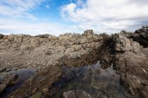 Côtes déchiquetées rocheuses, rocher de grès érodé, vue sur l'océan — Photo de stock