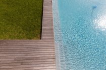 Luftaufnahme eines Swimmingpools mit Terrassenrand und Pflanzen in einem Garten. — Stockfoto