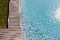 Vista aérea de uma piscina com uma borda de convés e plantas em um jardim. — Fotografia de Stock