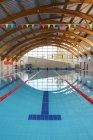 Indoor swimming pool with marked lanes, flat calm water — Stock Photo