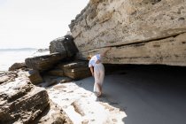 Teenage girl exploring the cliffs and rock strata on a beach on the Atlantic shore. — Foto stock