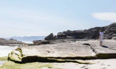 Teenage girl exploring a rocky shore on the Atlantic ocean coastline — Foto stock