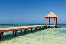 Pier over turquoise blue water on the beach — Stock Photo
