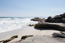 Teenage girl exploring a rocky shore on the Atlantic ocean coastline — Stockfoto