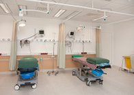Обслуговування пацієнтів у сучасній лікарні, ліжка та пацієнтів, електронне обладнання та штори — стокове фото