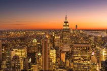 Эмпайр-стейт-билдинг, возвышающийся над Манхэттеном на восходе или закате. — стоковое фото