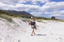 Erwachsene Frau trägt Picknickkorb am Grotto Beach, Hermanus, Western Cape, Südafrika. — Stockfoto