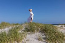 Adolescente envuelta en blanco, Grotto Beach, Hermanus, Western Cape, Sudáfrica. - foto de stock