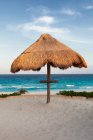 Palapa ombra di paglia sulla spiaggia. — Foto stock