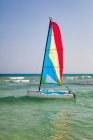 A catamaran in shallow water with the sail up. — Stockfoto