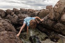 Jovem rapaz explorando piscina de maré, De Kelders, Western Cape, África do Sul. — Fotografia de Stock