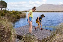 Adolescente e irmão mais novo explorando lagoa, Stanford Valley Guest Farm, Stanford, Western Cape, África do Sul. — Fotografia de Stock