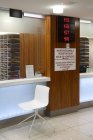 Зона очікування та стійка прийому в сучасній лікарні з вивісками та електронним дисплеєм — стокове фото