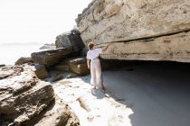 Adolescente explorant les falaises et les strates rocheuses sur une plage sur la rive atlantique. — Photo de stock
