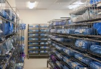 Storage room in a modern hospital, rows of sterile equipment packs in blue fabric. — Stock Photo