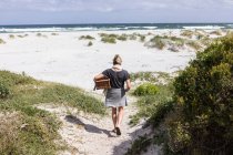 Femme adulte portant un panier de pique-nique sur Grotto Beach, Hermanus, Western Cape, Afrique du Sud. — Photo de stock