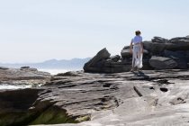Adolescente explorando una costa rocosa en la costa del océano Atlántico - foto de stock