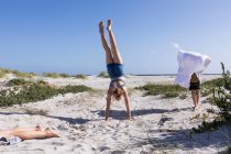 Teenage girl doing hand stand, Grotto Beach, Hermanus, Western Cape, South Africa. — Stock Photo