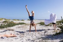 Teenage girl doing hand stand, Grotto Beach, Hermanus, Western Cape, South Africa. — Foto stock